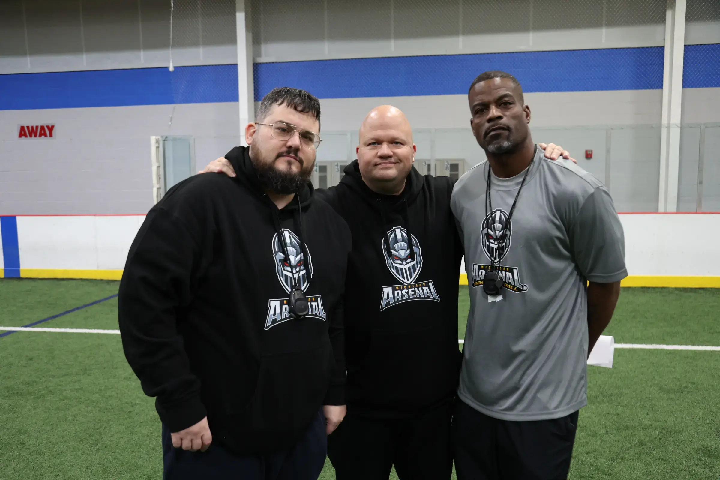 Michigan Arsenal coaching staff standing together on the indoor field